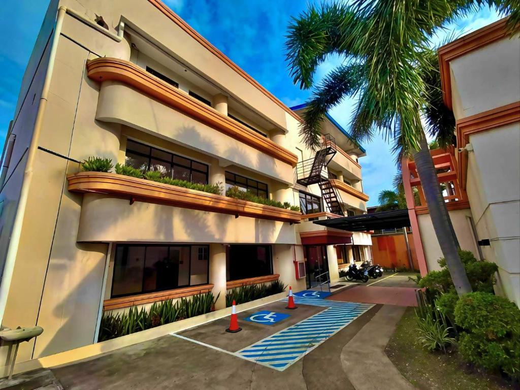 a building with a palm tree in front of it at Hotel Casa Ilustre in Balayan