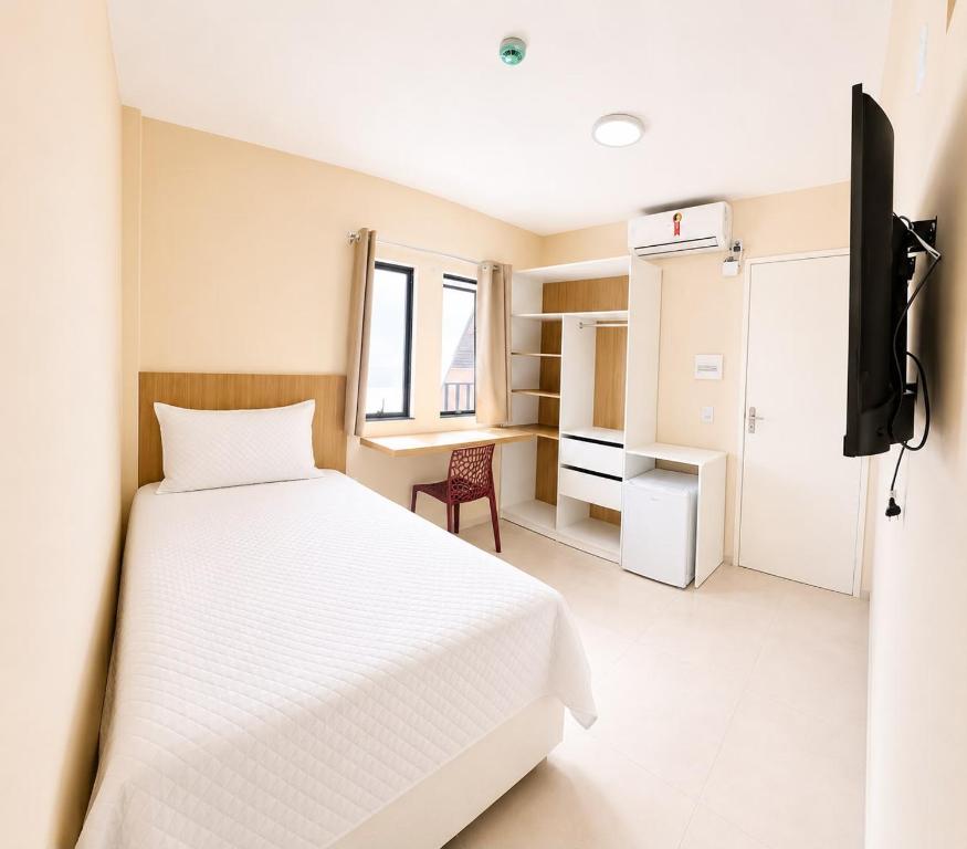 a bedroom with a bed and a tv in it at Pousada Milagres in Canindé