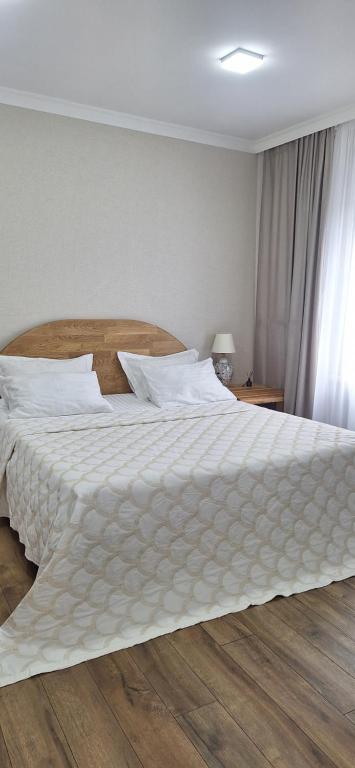a bedroom with a large bed with a white comforter at Poduszka mini-hotel in Stantsiya Rokitno Volynskoye