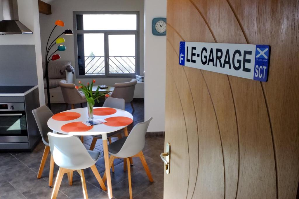 - une cuisine et une salle à manger avec une table et des chaises dans l'établissement Appart'hôtel "Le Garage", à Saint-Bonnet-en-Champsaur