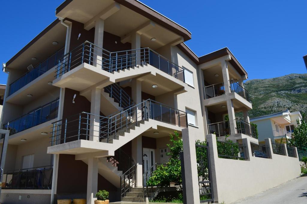 een appartementencomplex met balkons en een berg bij Apartments Md Lux 2 in Sutomore