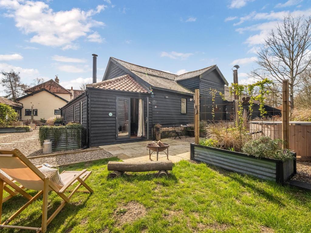 a backyard with a black house and a lawn with a chair at The Old Press - Uk50806 in Halesworth