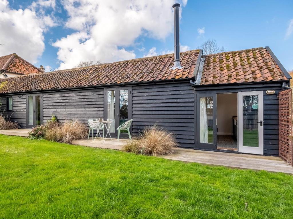 a detached house with a patio and lawn at The Cowshed - Uk50803 in Cratfield