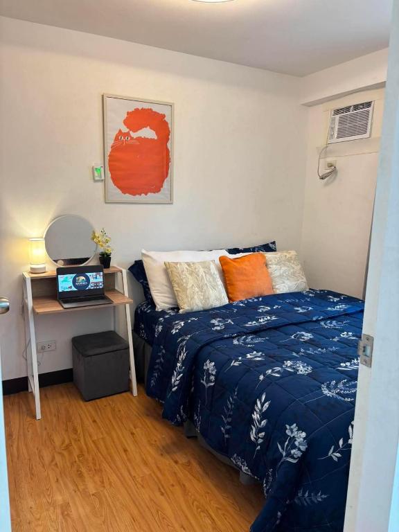 a small bedroom with a bed and a desk at Arezzo Place in Davao City