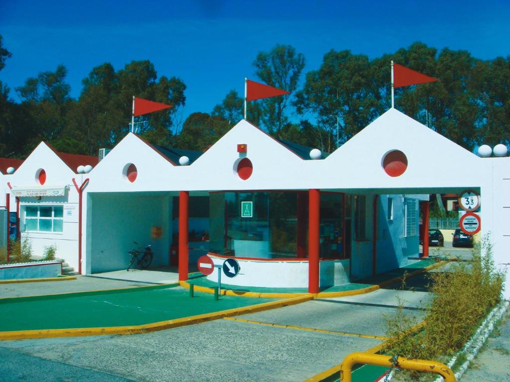 a gas station with red flags on top of it at Camping Playa Las Dunas in El Puerto de Santa María