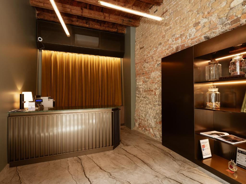 a bar in a restaurant with a brick wall at Ca Moroni Collection in Bergamo