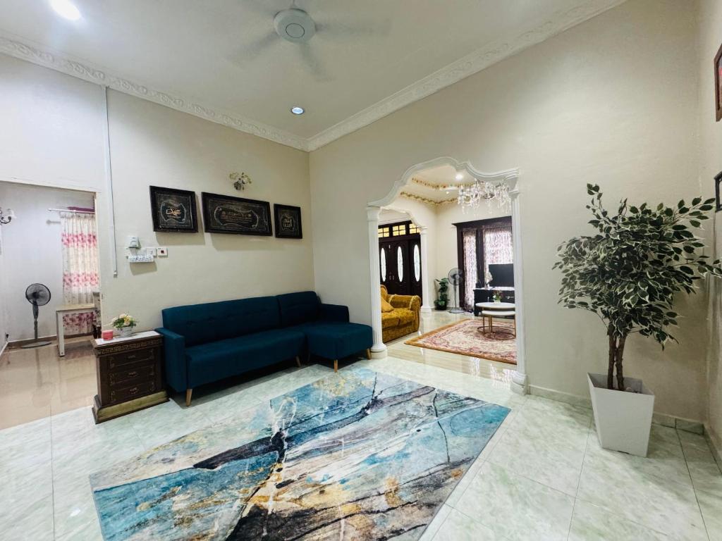 a living room with a blue couch and a table at Taman Darul Salam Homestay Pasir Puteh in Pasir Puteh