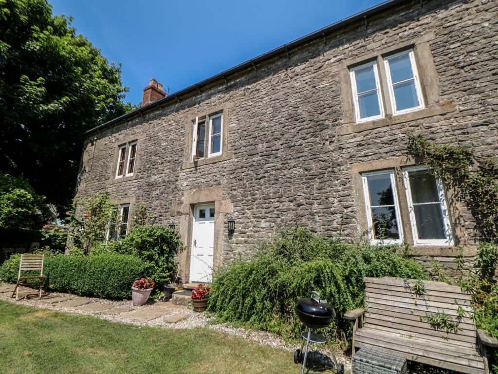 a brick house with a bench in front of it at Slade House in Ashbourne