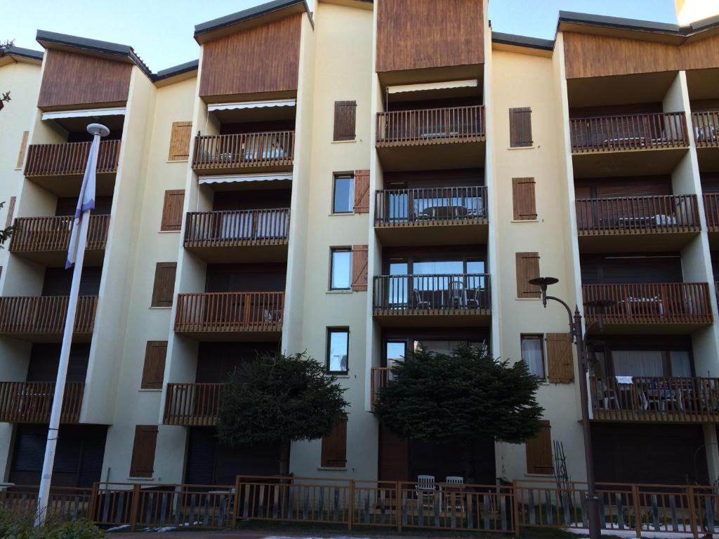 un immeuble d'appartements avec balcon et arbres dans l'établissement Le Plazza, à Valberg