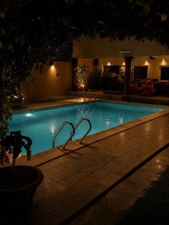 a large swimming pool at night with at Roc Heights in Bakau