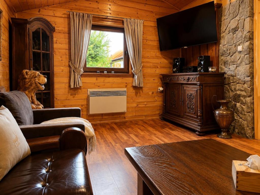 a living room with a couch and a television at Chata Medvedík in Turík