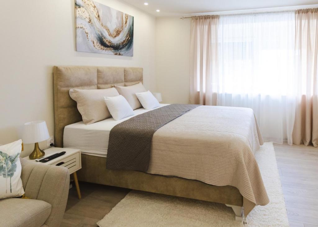 a bedroom with a large bed and a couch at apartman STUDIO ELEGANCE in Bečej
