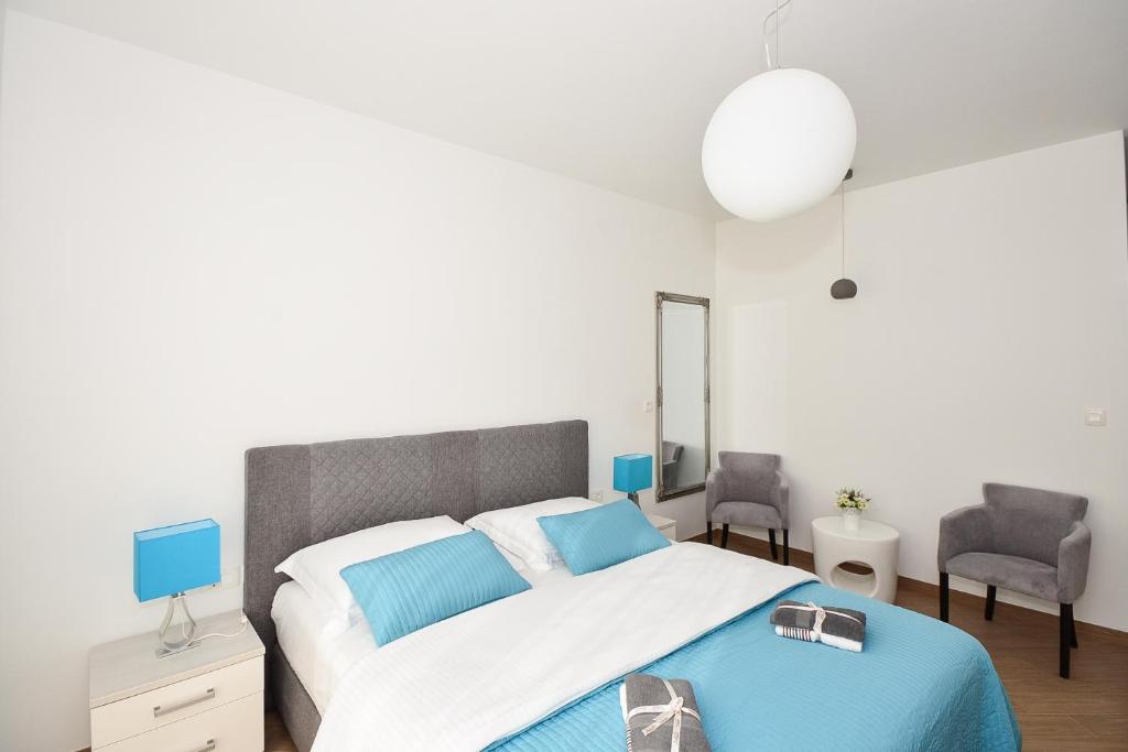 a bedroom with a large bed and two chairs at Apartment & Room Ladisic in Orasac