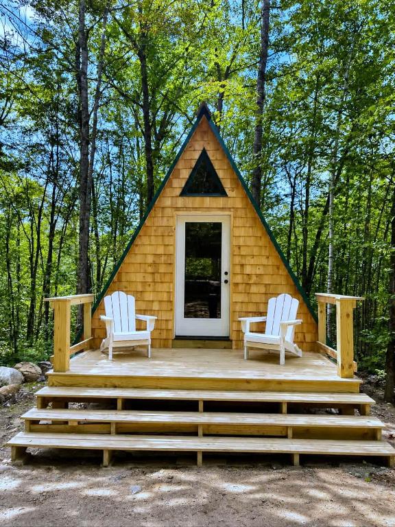 a tiny house with two chairs and a porch at White Mountains A-Frame Off-Grid Stars Firepit in North Lovell