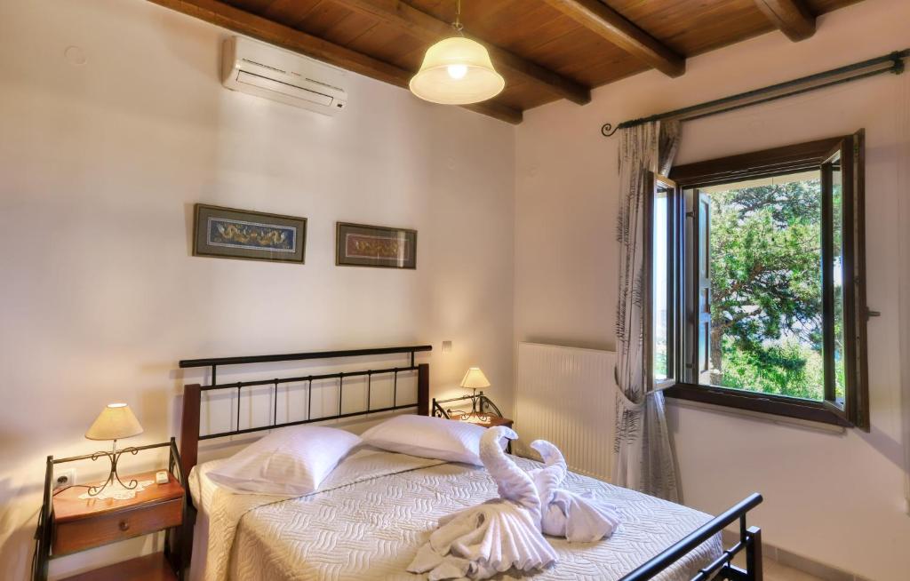 a bedroom with a bed with a large window at Rodoula apts By Comfortbnb in Roússa Ekklisía