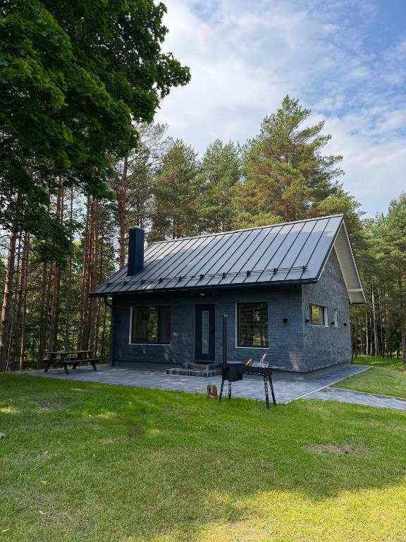 a stone house with a metal roof at Beiri in Dravnieki