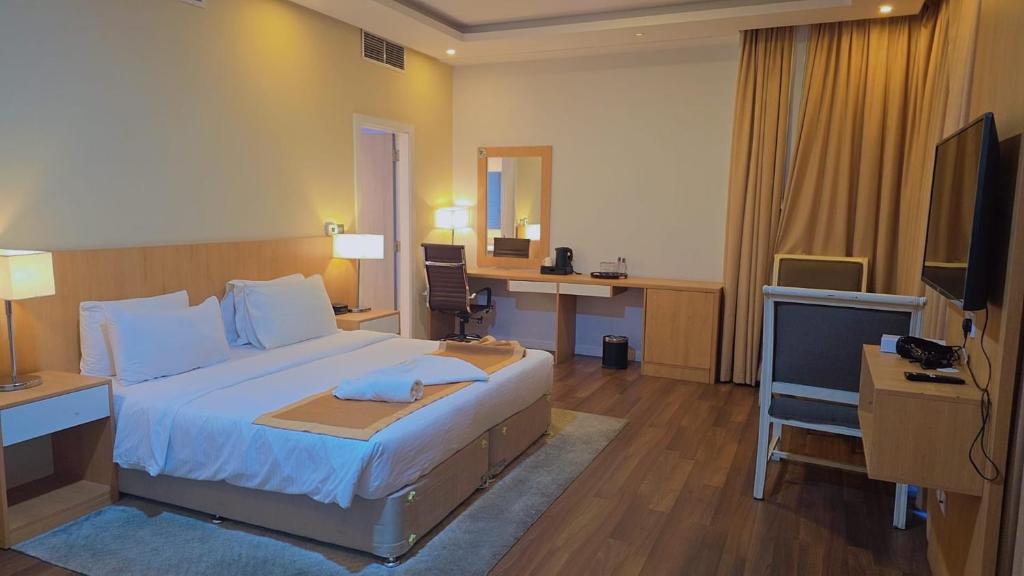 a hotel room with a bed and a desk and a television at Mirador Hotel in Manama