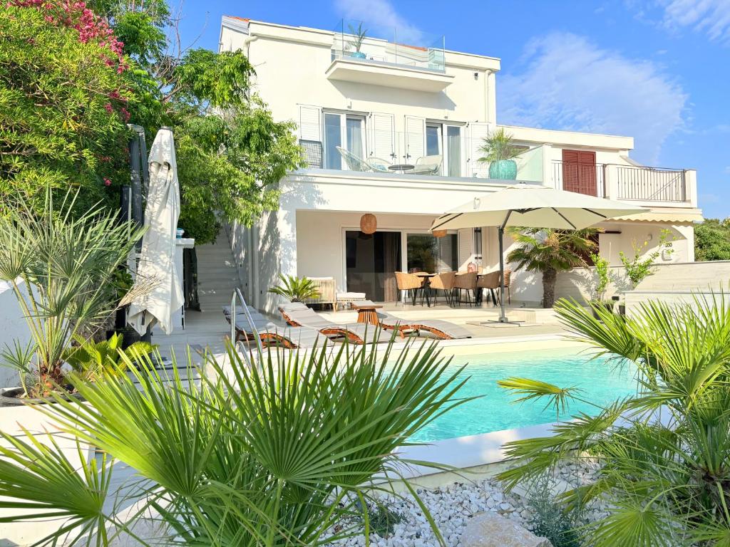 a villa with a swimming pool and a house at Villa TerraAurora in Barbat na Rabu