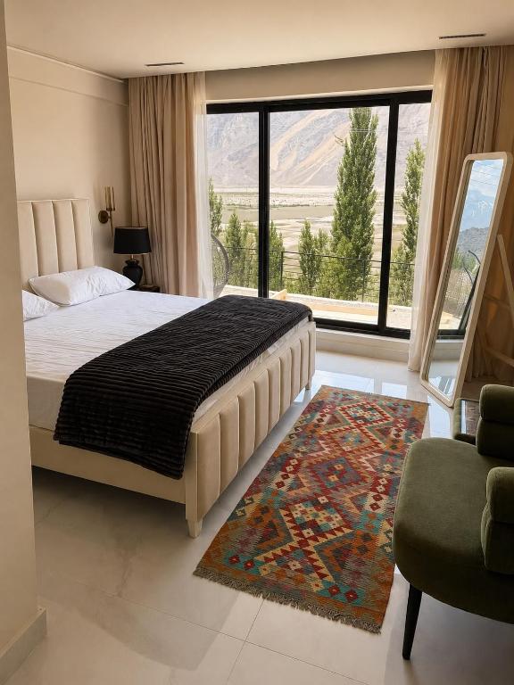 a bedroom with a large bed and a large window at Lamhay Private lodges in Skardu