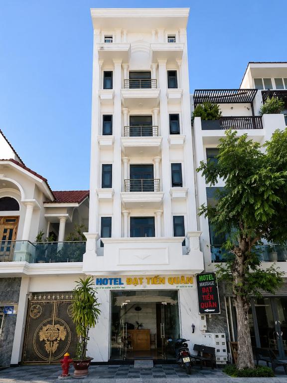 a white building with a sign in front of it at Khách sạn Đạt Tiến Quân in Ấp Bình Hưng