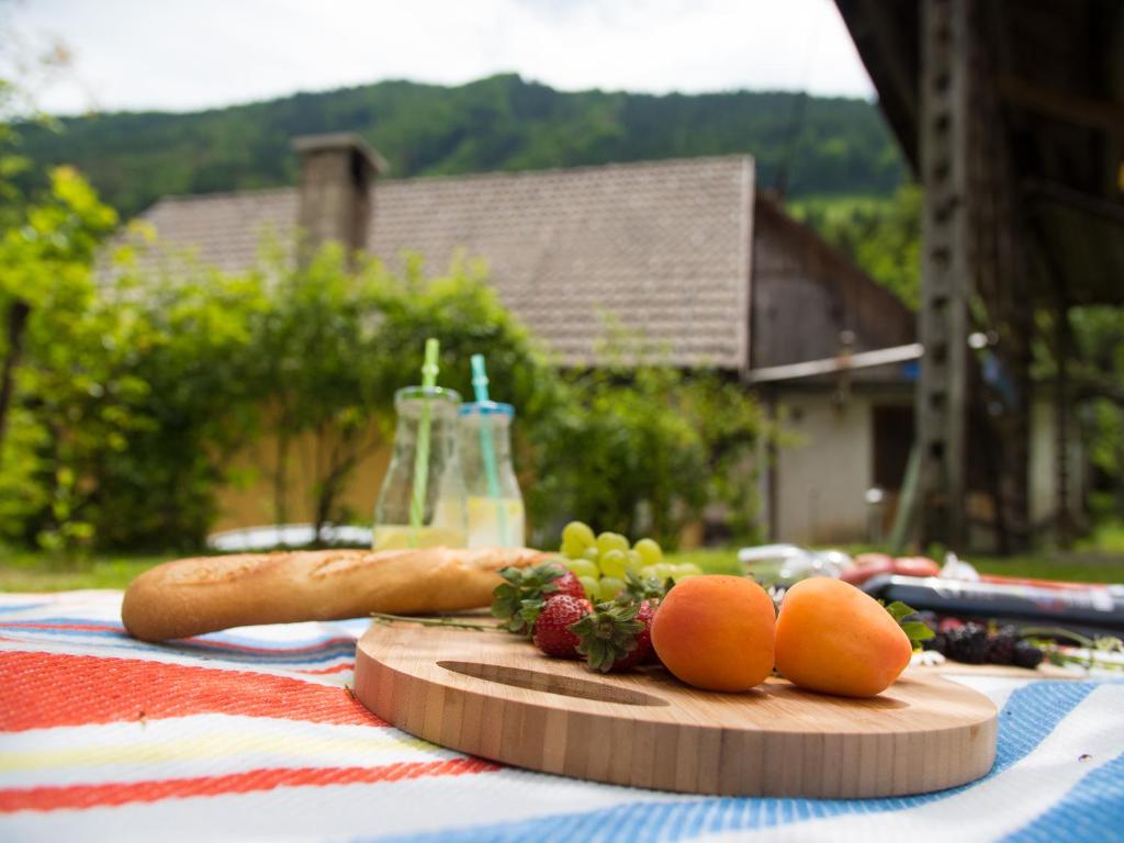 una tabla de cortar con frutas y hortalizas sobre una mesa en Cosy Apartment Pr Potokar, en Podlonk