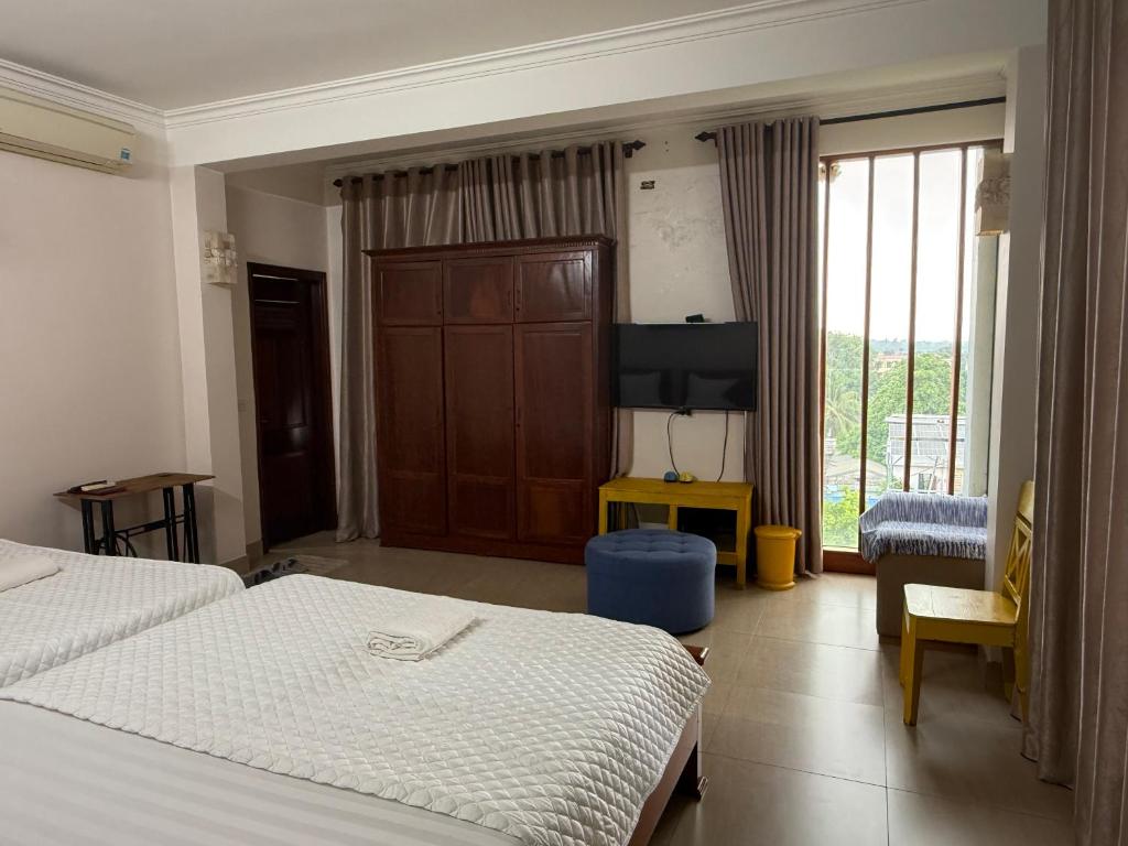 a hotel room with two beds and a flat screen tv at Khách sạn Hùng Thắng in Vĩnh Lộc