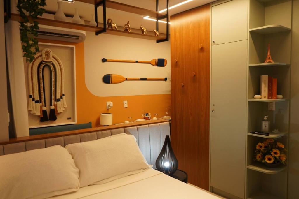 a bedroom with a bed and a shelf with baseball bats at Tiwa Studio Requinte Amazônico Adrianópolis in Manaus