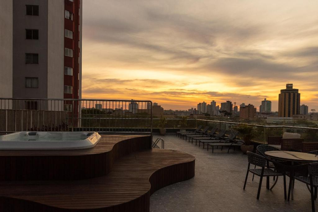 a hot tub on a balcony with a view of a city at Village Iguassu Hotel in Foz do Iguaçu