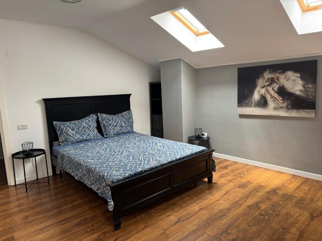 a bedroom with a bed and a painting on the wall at Dare apartments 1 in Giurgiu