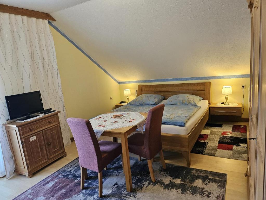 a bedroom with a bed and a table and chairs at Haus am Schönberg in Sooss