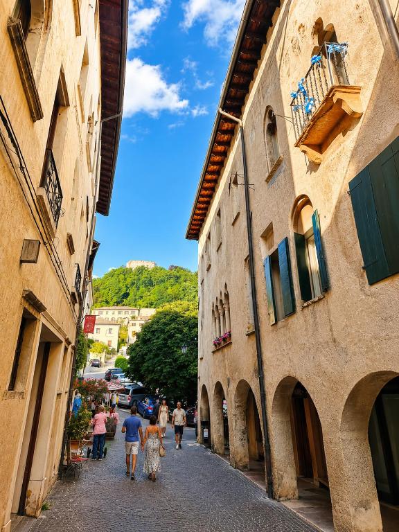a group of people walking down a street between two buildings at Residenza Dante Luxury Apartment nel Centro Storico in Asolo