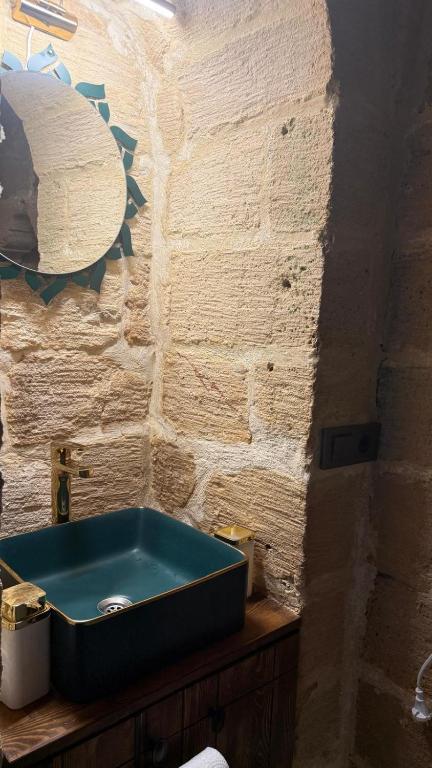 a bathroom with a blue sink on a counter at Alies Konağı in Mardin
