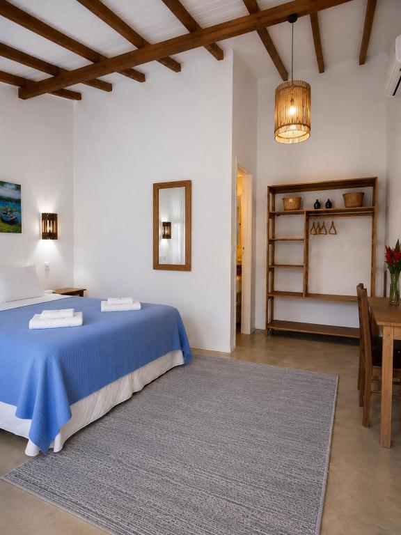 a bedroom with a blue bed and a table at Viva Vida Caraiva in Caraíva