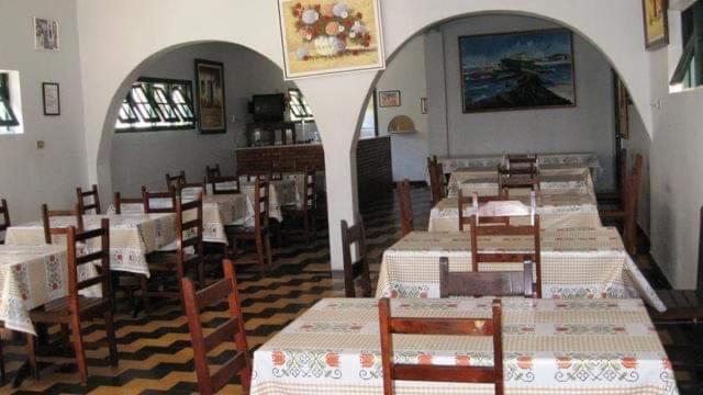 a dining room with tables and chairs in a restaurant at Hotel Nanuque in Cabo Frio