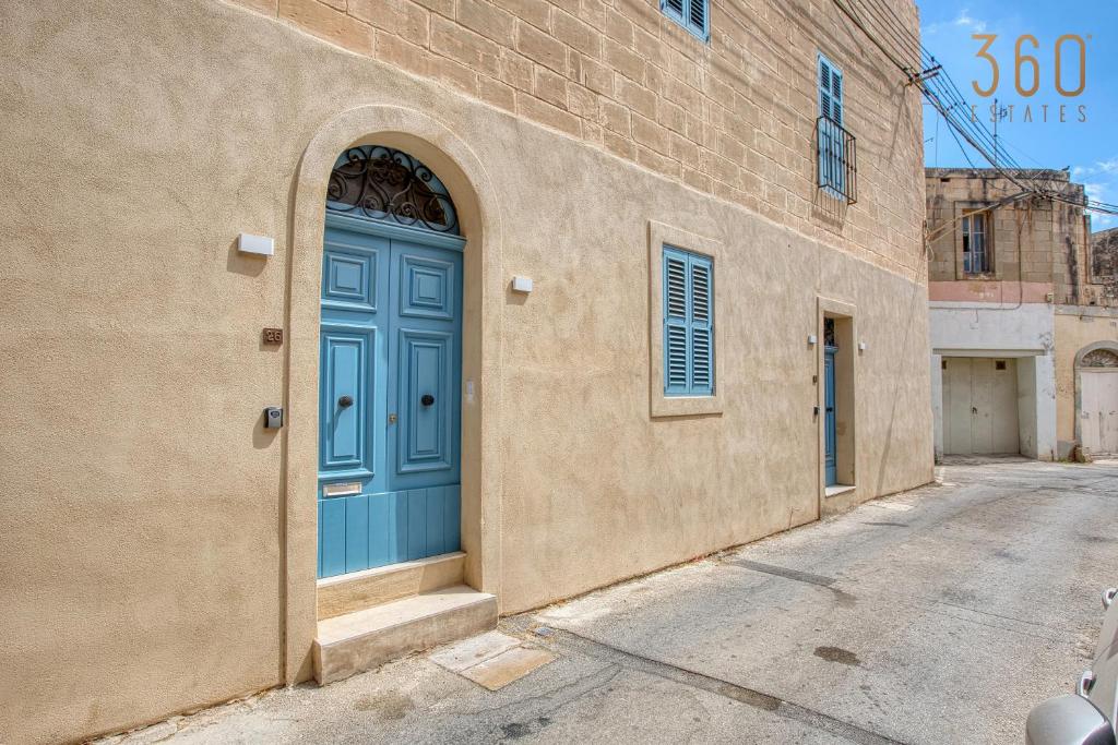 a blue door on the side of a building at Luqa Stone Maisonette Apartments Near Airport in Luqa