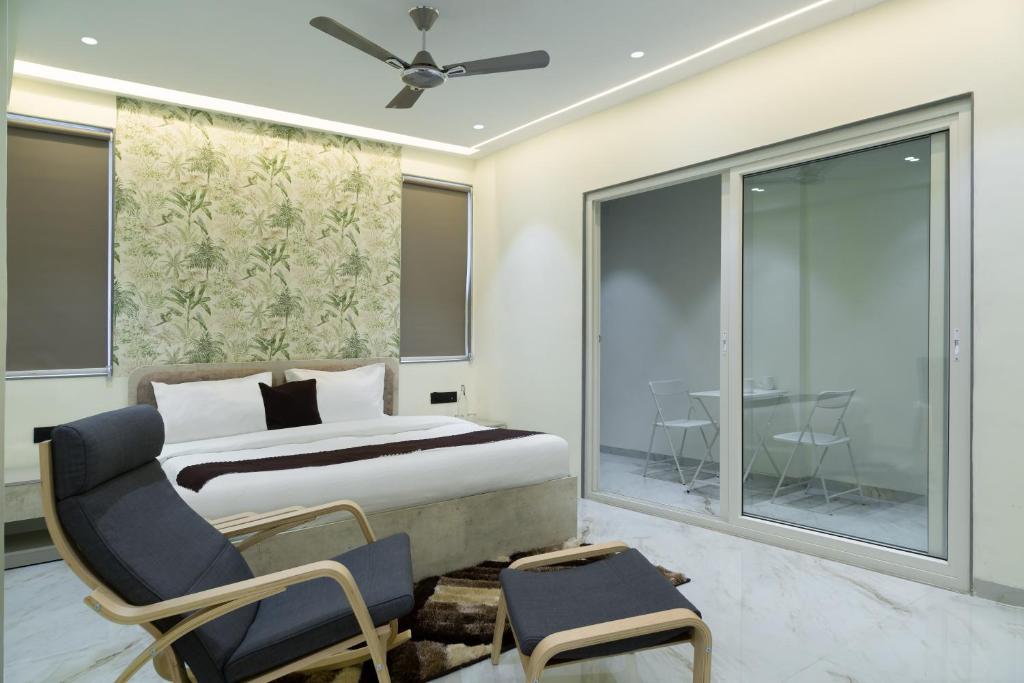 a bedroom with a bed and a chair and a window at Dwarka Palace in Hingoli