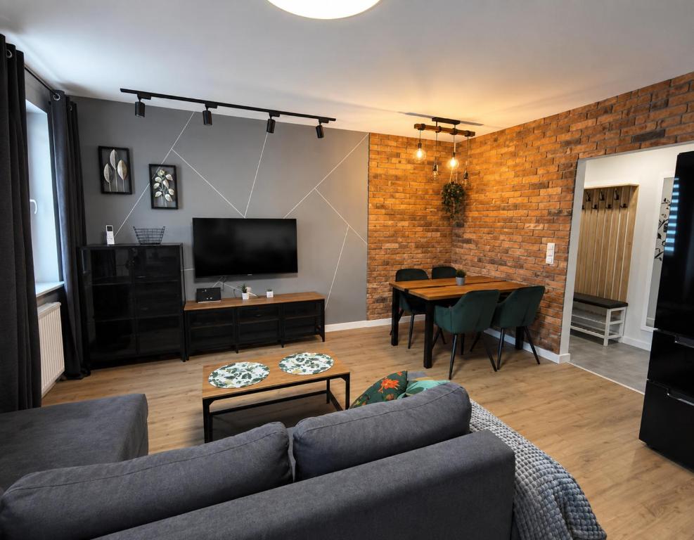 a living room with a couch and a table at Loft No 35 Premium Apartment in Głogów