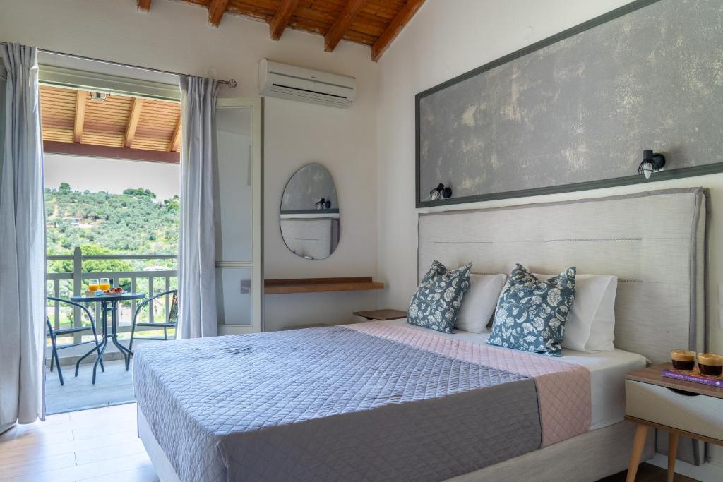 a bedroom with a bed and a balcony at Flower in Skiathos