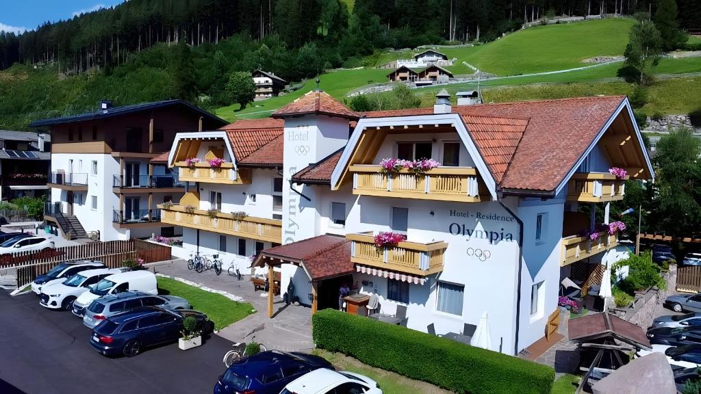 arial view of a hotel with cars parked in a parking lot at Hotel Residence Olympia Sarntal in Sarntal