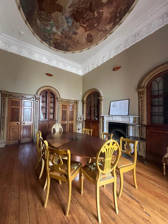 a dining room with a table and chairs and a ceiling at Uppercourt Manor in Freshford