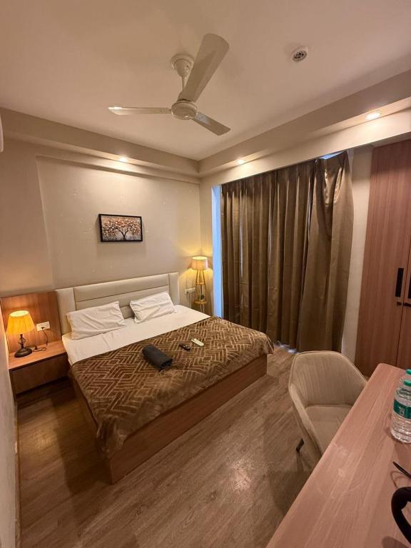 a bedroom with a bed and a chair in it at stay elan in Greater Noida