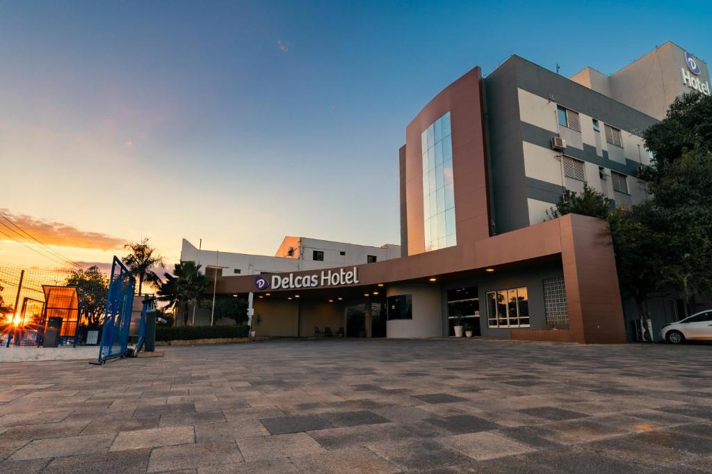 ein Gebäude mit einem davorliegenden Parkplatz in der Unterkunft Delcas Hotel in Cuiabá
