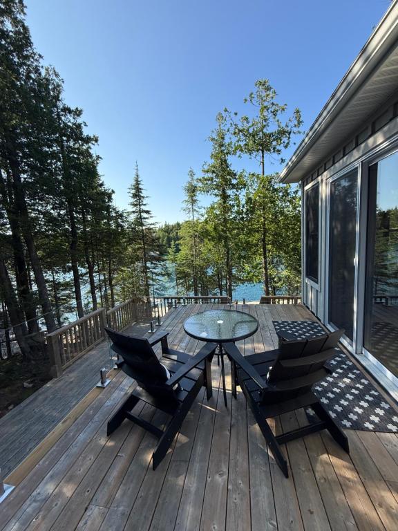 a patio with a table and chairs on a deck at Dock 124 - Adults Only, Waterfront B&B in Tobermory