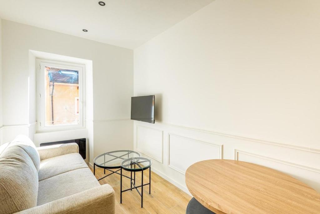 a living room with a couch and a table at L'Aube des Alpes Hyper Centre Élégance et Confort in Thonon-les-Bains