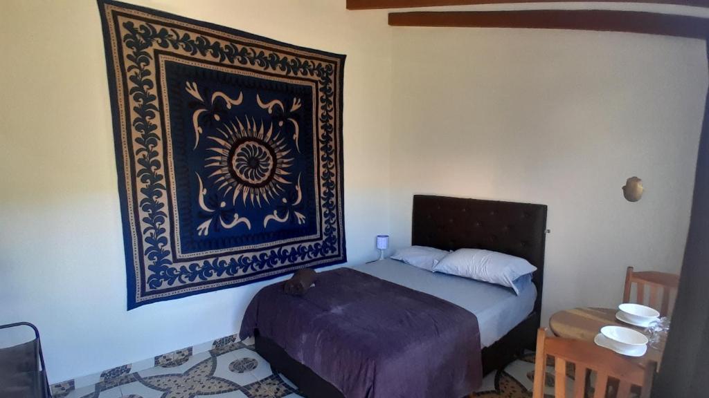 a bedroom with a bed and a picture on the wall at El Nido in Samaipata