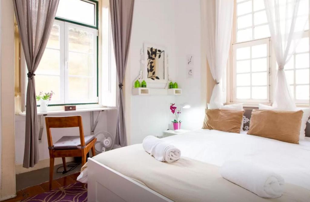 リスボンにあるCharming apartment in Alfama - Se11のベッドルーム1室(ベッド2台、デスク、窓付)