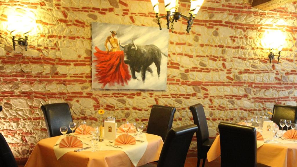 ein Esszimmer mit zwei Tischen und einem Gemälde an der Wand in der Unterkunft Bawelsberger Hof in Dillingen an der Saar