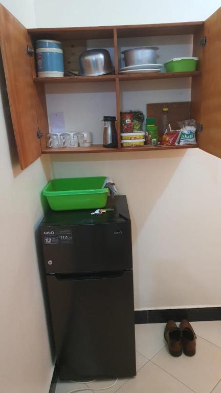 a kitchen with a green container on top of a refrigerator at Masaka BnB in Masaka