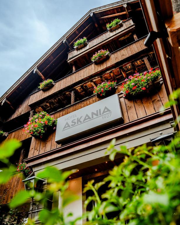a sign on the side of a building with potted plants at Hotel Askania 1927 in Bad Wiessee