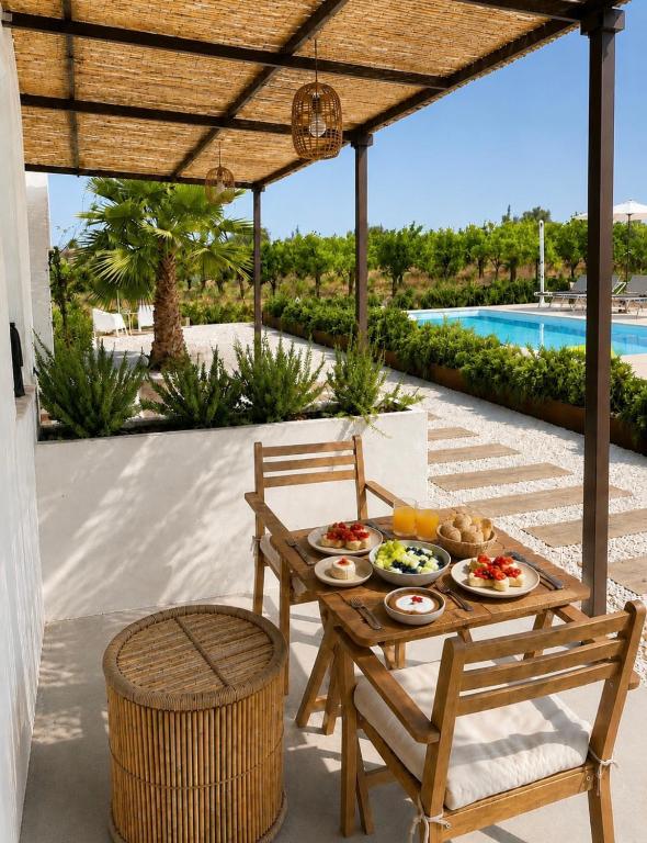 a table and chairs on a patio with a pool at Ziran in Noto